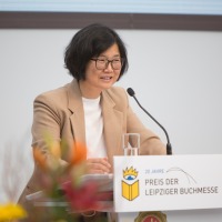 Die Gewinnerin Ki-Hyang Lee bei ihrer Dankesrede am Rednerpult bei der Verleihung vom Preis der Leipziger Buchmesse 2024