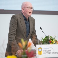Der Gewinner Tom Holert bei seiner Dankesrede am Rednerpult bei der Verleihung vom Preis der Leipziger Buchmesse 2024